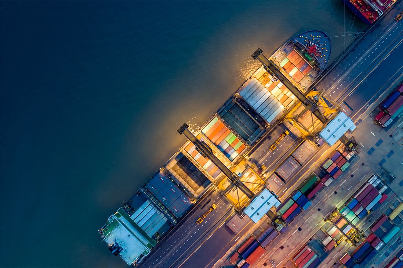 Shipping containers being loaded at a shipping yard.